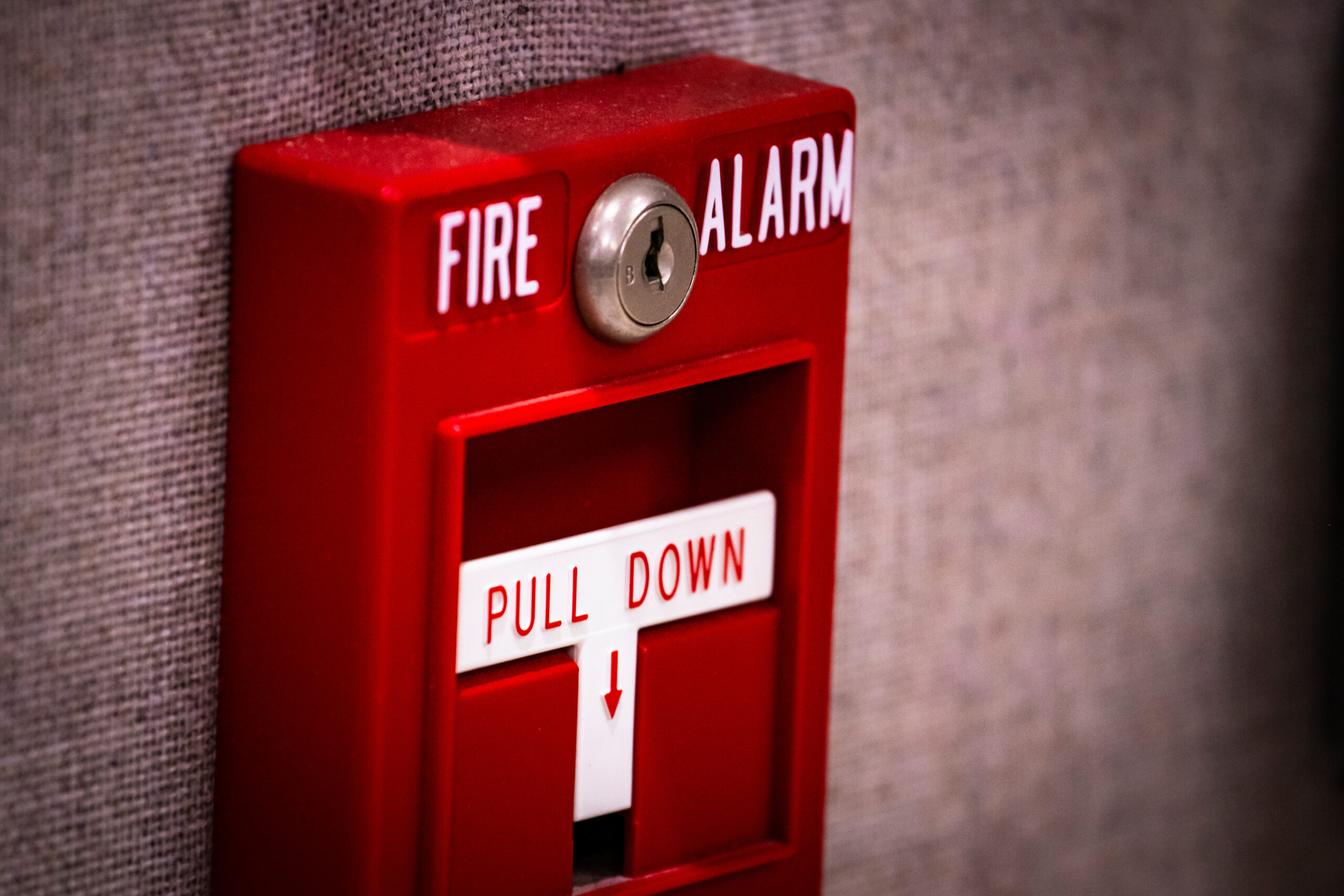 Manual fire alarm activation pull station on wall signage read